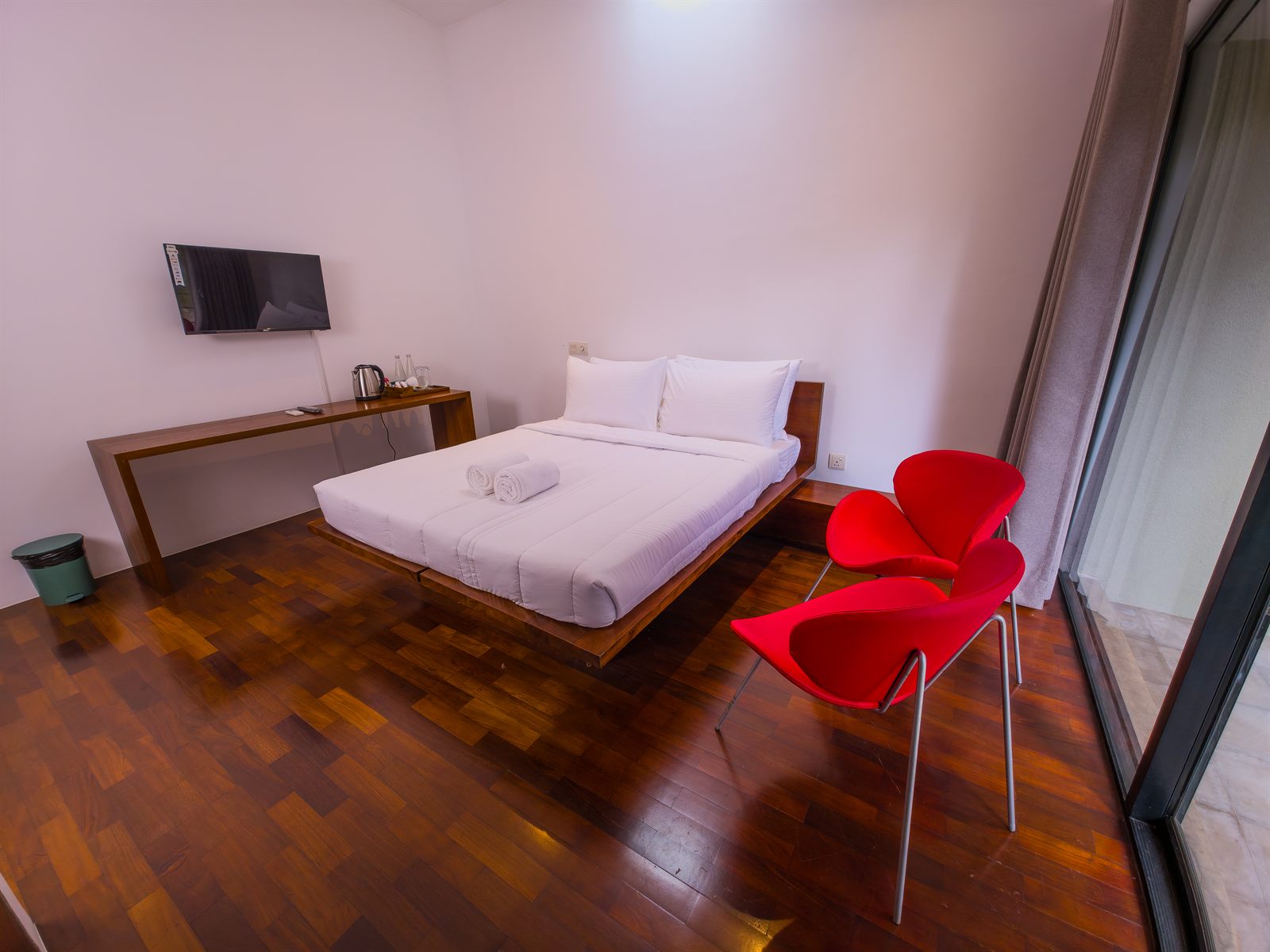 Deluxe Room wide view with wooden floor and seating