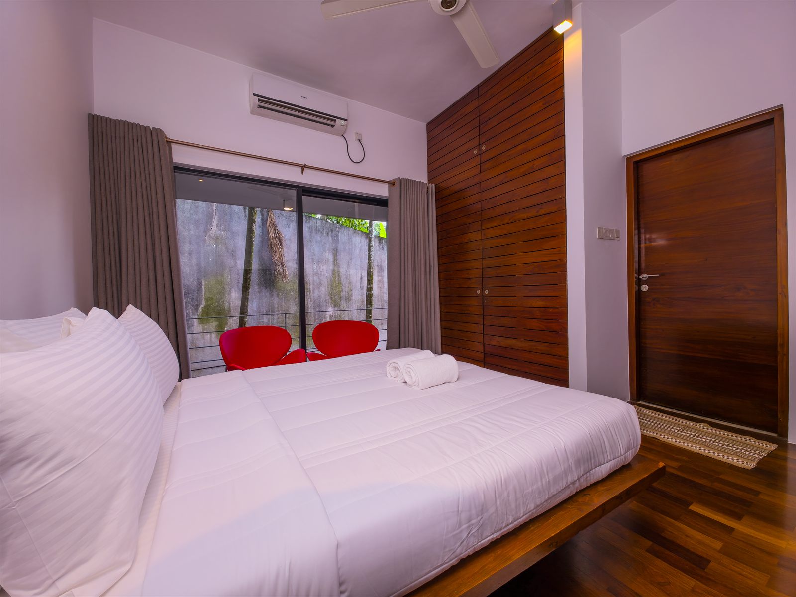 Deluxe Room bed and balcony seating